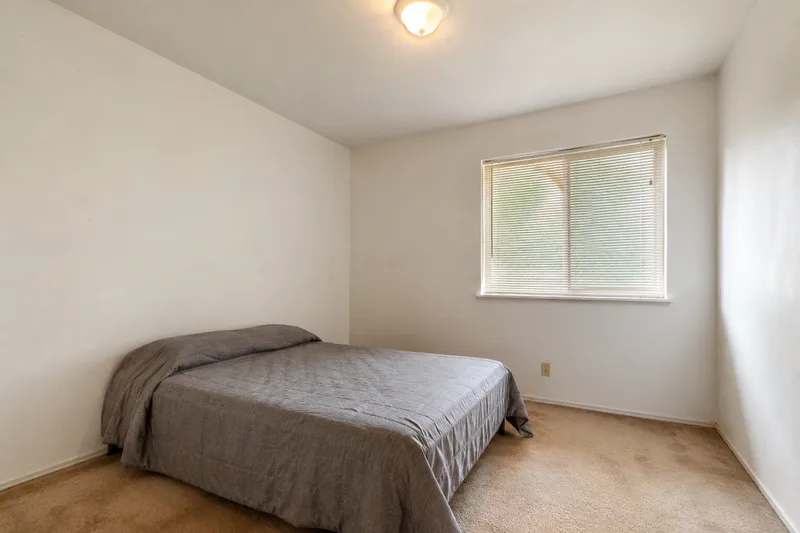 Plain dated bedroom before an AI redesign